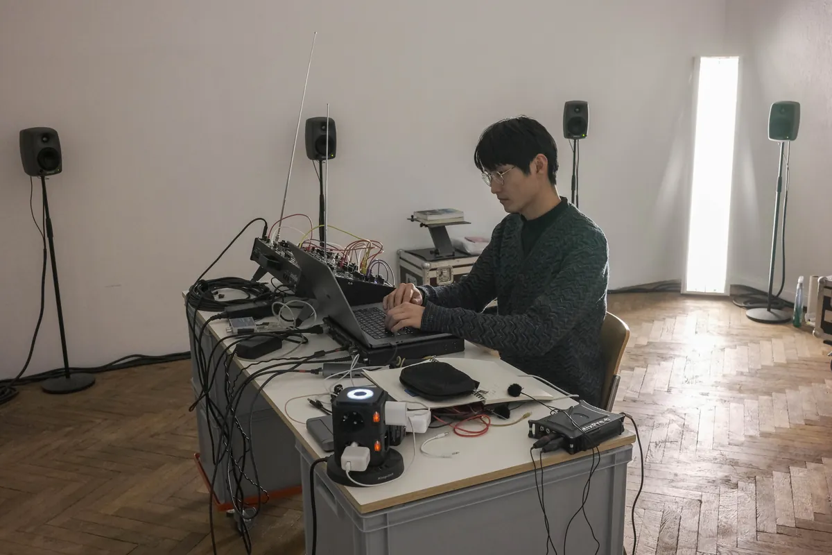 Zhao Jiajing at a desk with electronics and loudspeakers